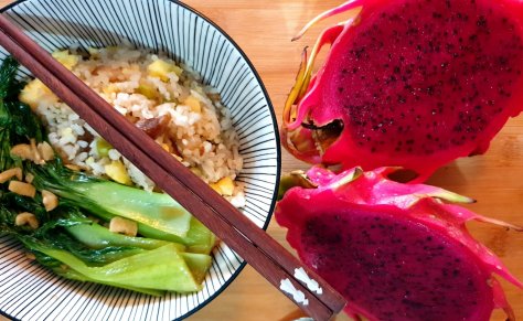 Oriental rice meal with vegetables and dragon fruit on the side